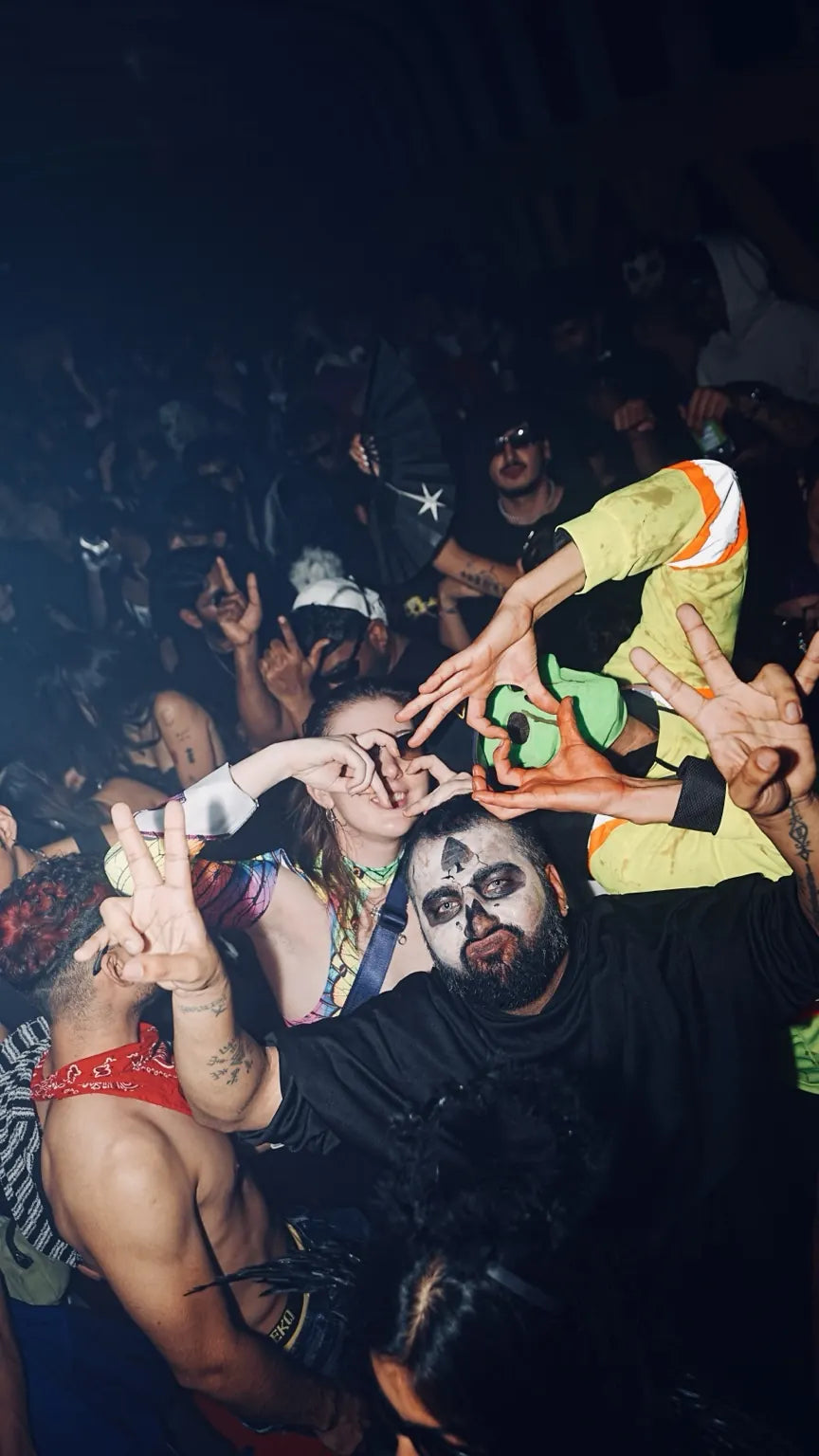 A group of friends posing in Halloween costumes in the crowd
