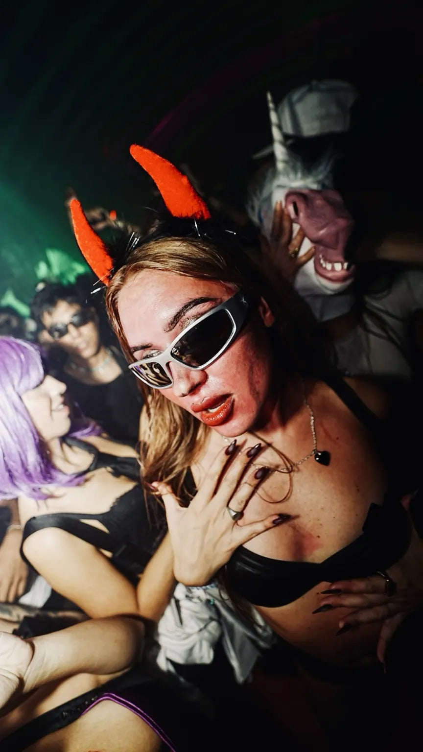 A guest wearing orange devil horns and white sunglasses at Halloween 2025